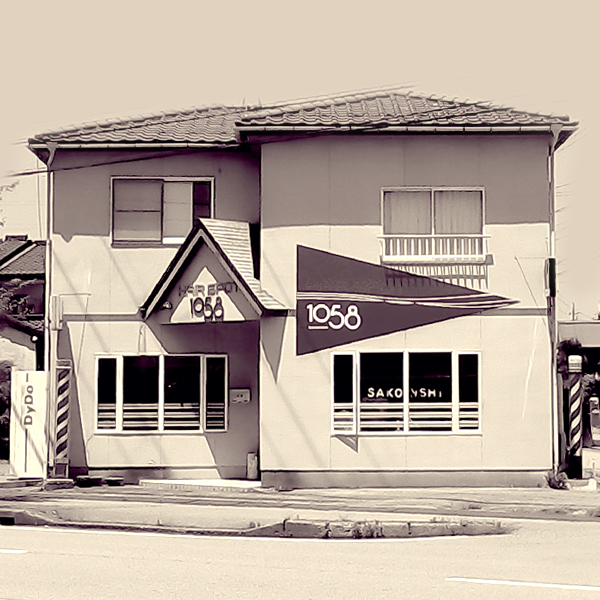 外観。赤い看板が目印の、黄色い建物が当店です。